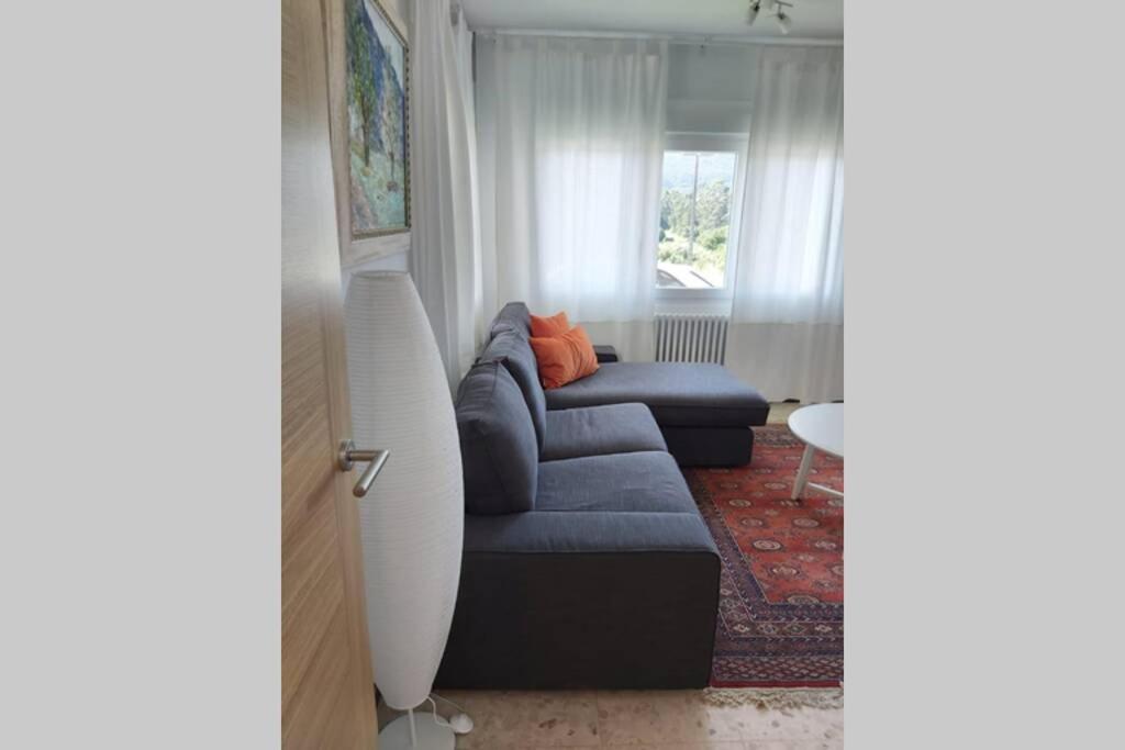 O Casal PontevedraChalet Meu Lar的客厅设有蓝色的沙发和窗户。