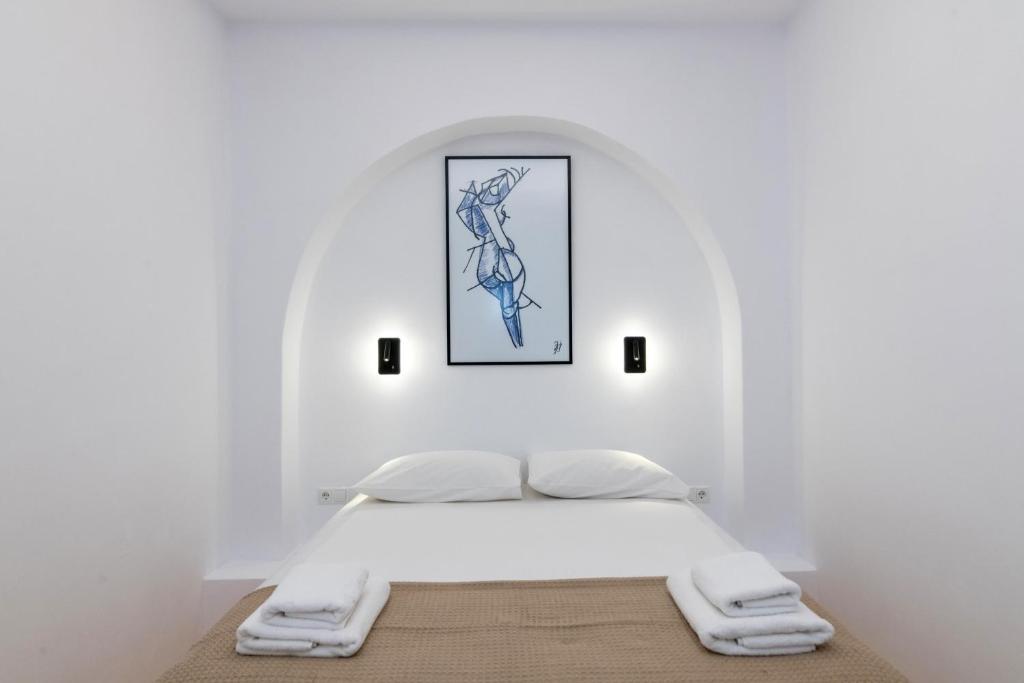 提诺斯Acanthus Houses的一张位于白色房间的床,墙上挂着一幅画