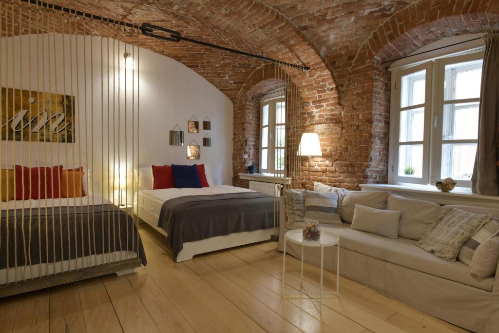 萨格勒布Apartment Azalea的一间卧室配有床、沙发和砖墙