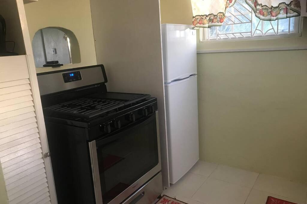 基督教堂市Sasha’s Holiday Home Oistins Barbados的小厨房配有炉灶和冰箱
