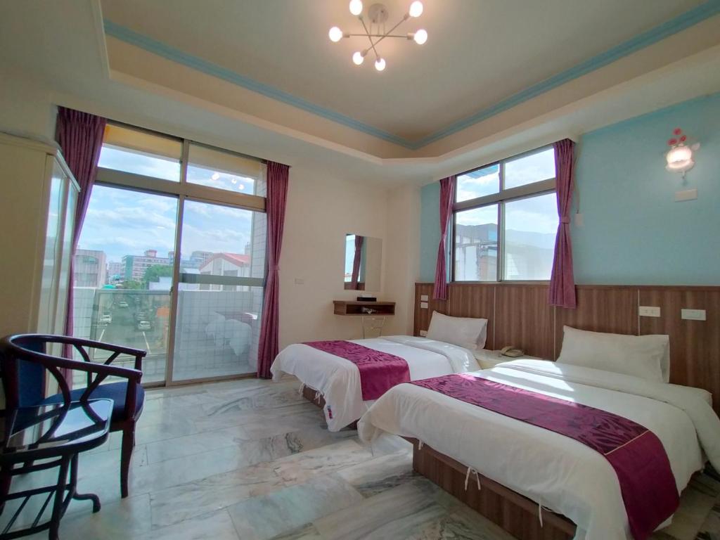 花莲市陶陶居商旅 Tautauchu Hotel的带大窗户的客房内的两张床