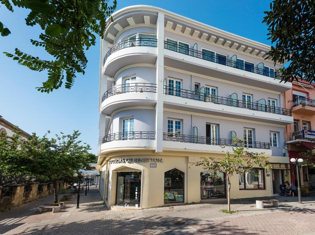 罗德镇赫耳墨斯酒店的一条高大的白色建筑,在街上设有阳台