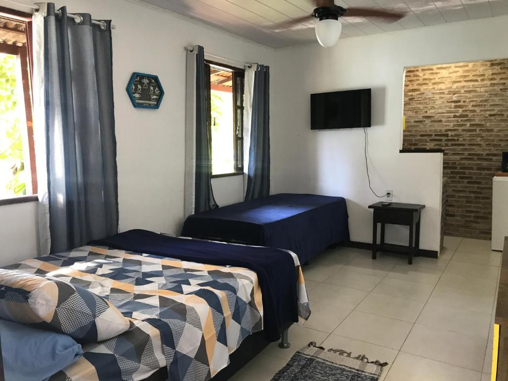 阿布拉奥Praia Comprida Flats的一间卧室配有一张床和一台平面电视