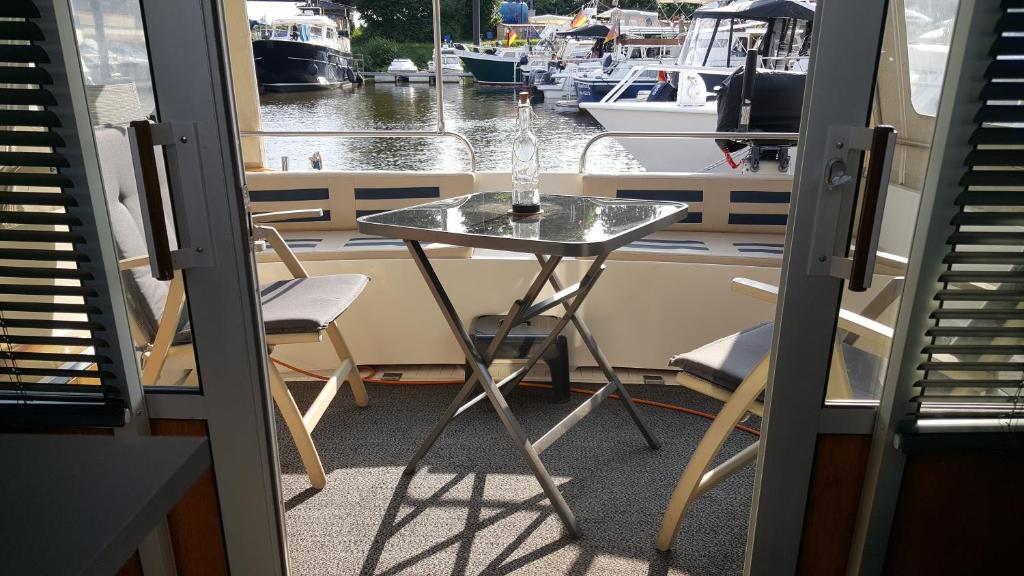 劳恩堡Kappoleni - ein Boot für dich的船上的一张桌子和一瓶玻璃