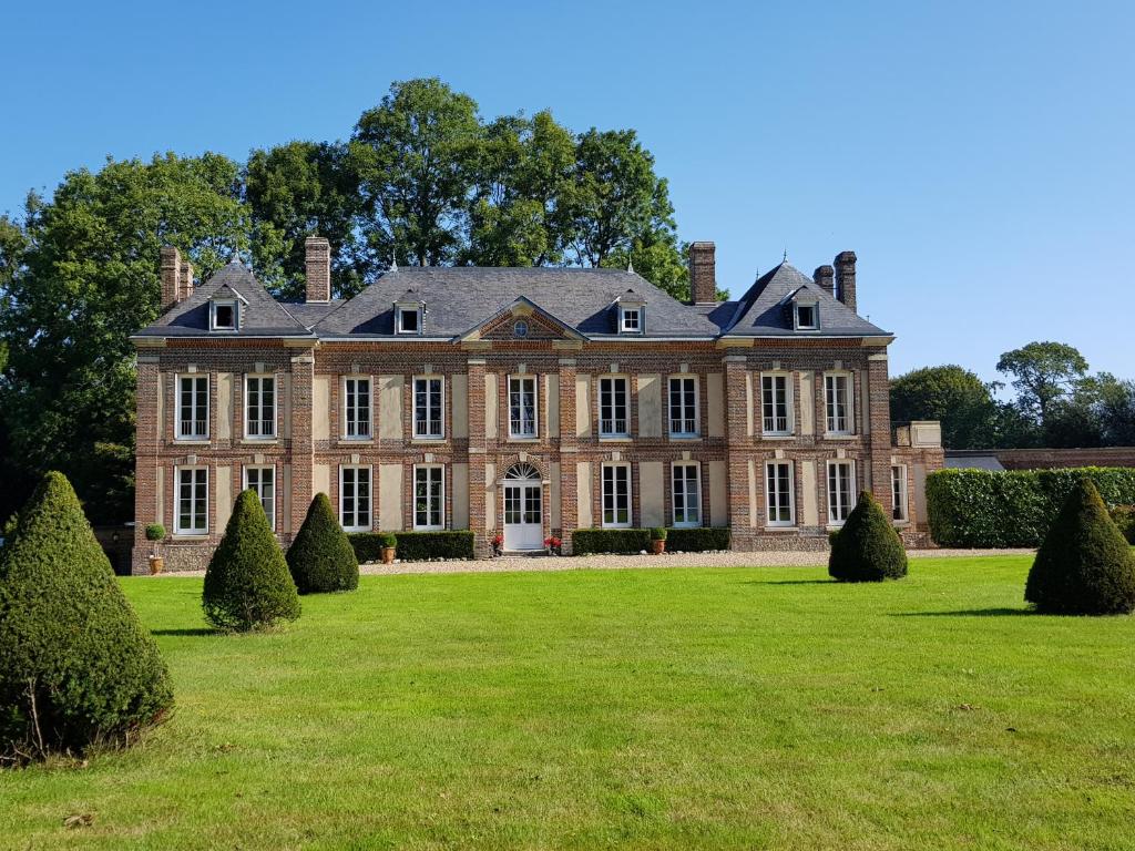 CleuvilleChâteau de Cleuville的一座拥有大草坪和树木的古老豪宅