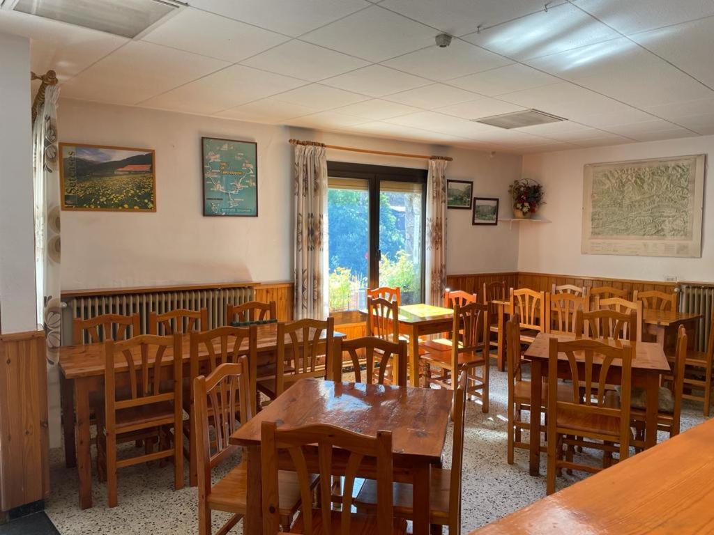 塞特卡萨斯Hostal Ter的用餐室配有木桌和椅子