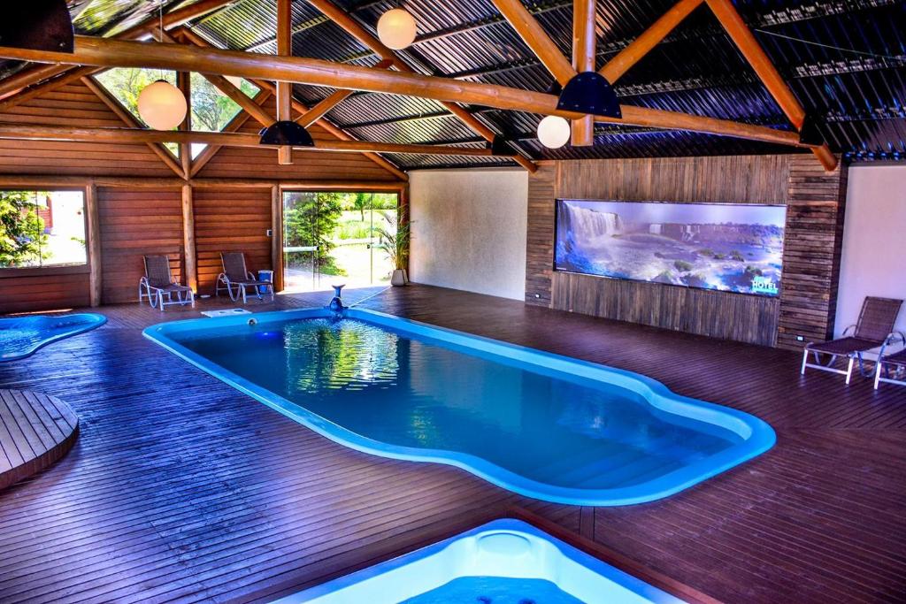 圣若泽杜斯皮尼艾斯布干维尔生态旅馆的带电视的客房内的大型游泳池
