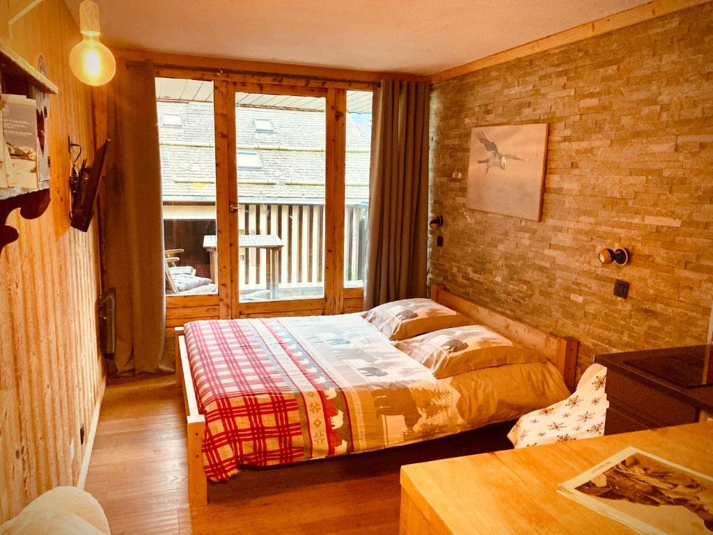 夏蒙尼-勃朗峰Le Gypaète的一间带床的卧室,位于带窗户的房间内