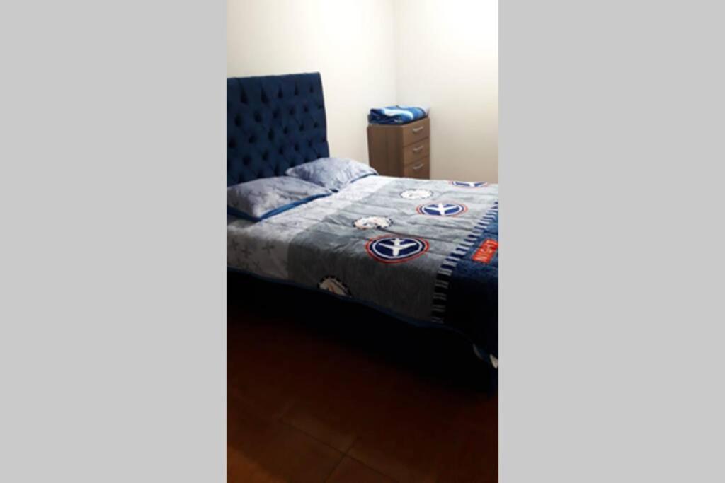 利马Hermoso departamento en chorrillos的一间卧室配有一张带蓝色棉被的床