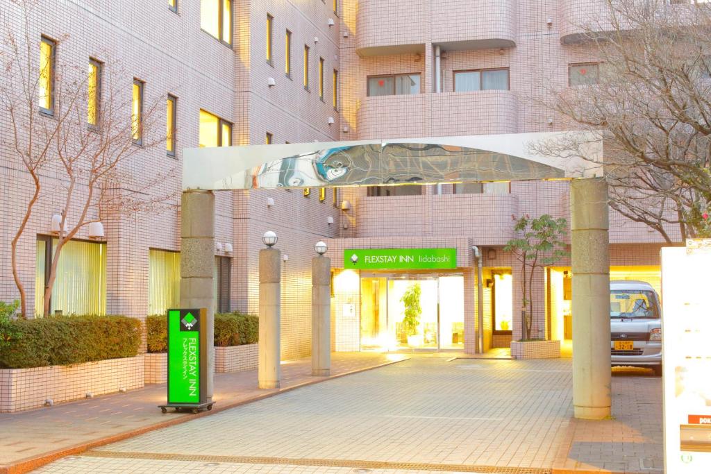 东京FLEXSTAY 饭田桥旅馆的前面有绿色标志的建筑