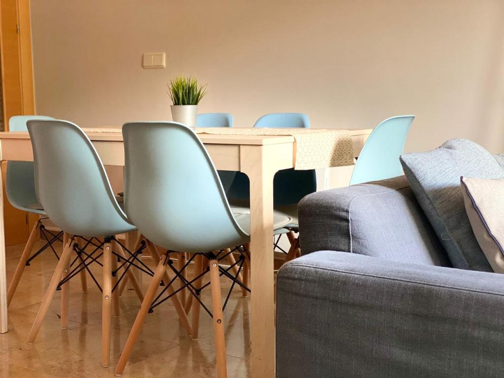 卡马雷纳德拉谢拉Apartamento Turístico Javalambre的一张带蓝色椅子和沙发的餐桌