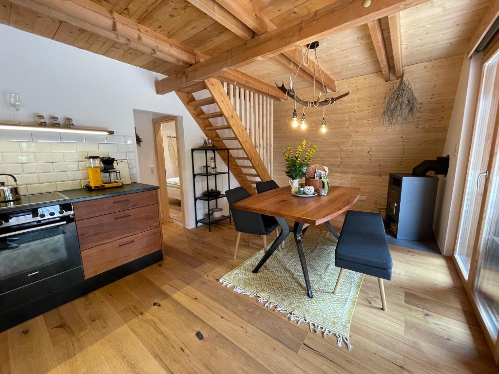 毛特Wildkräuter Hexenhaus的一间厨房和带木制天花板的用餐室