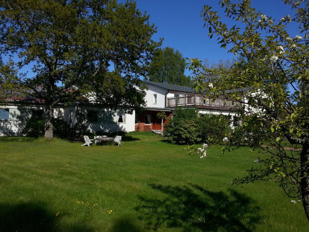 埃克勒Havsbandet Pensionat的白色的房子,有树的院子