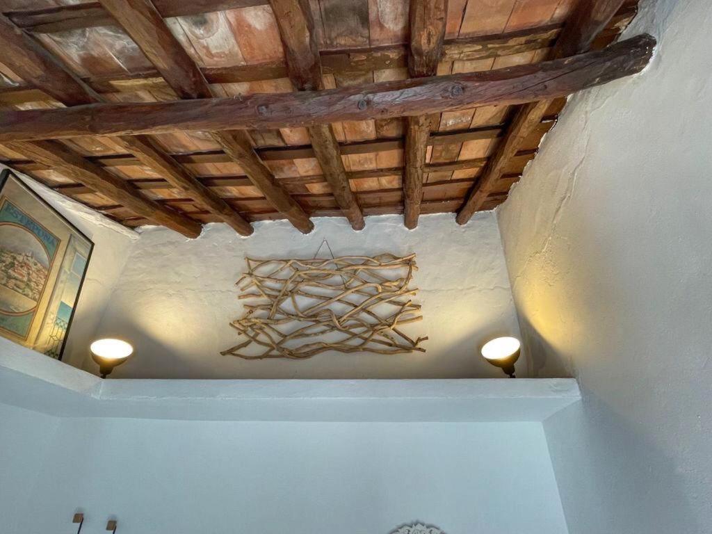 EsteponaCasita Beatriz - by Casa del Patio的一间带木天花板和吊灯的客房