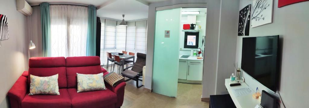 塞哥维亚El Balconcito de San Millan的一间带红色沙发的客厅和一间厨房