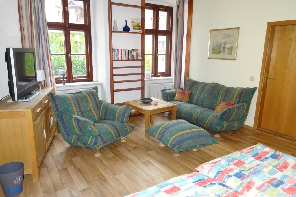 格尔利茨Müllers zweite Ferienwohnung in der Altstadt von Görlitz的客厅配有两把椅子和电视