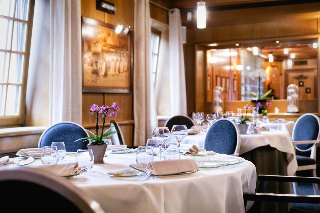 马尔勒南乐塞尔福餐厅及Spa酒店的用餐室配有桌椅和白色的桌布