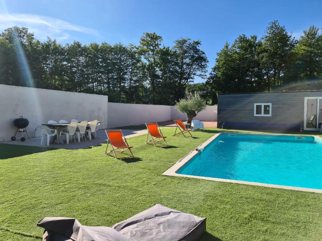勒克佐Gîte des Vernizeaux的后院设有游泳池、椅子和桌子