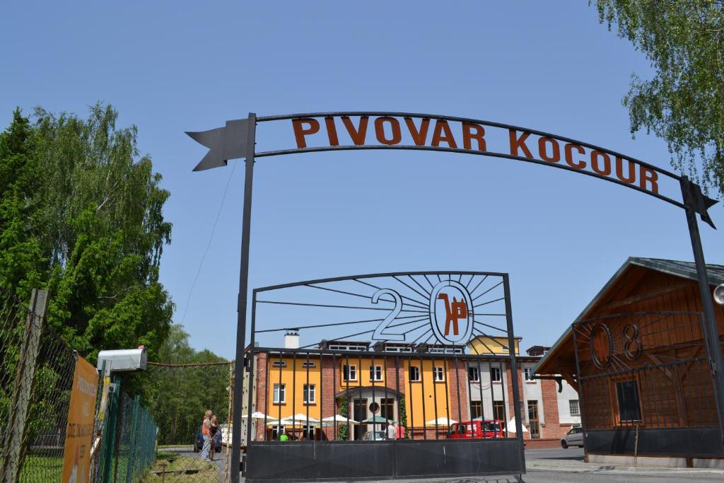 瓦恩斯多夫Pivovar Kocour的黄色建筑前面的标志