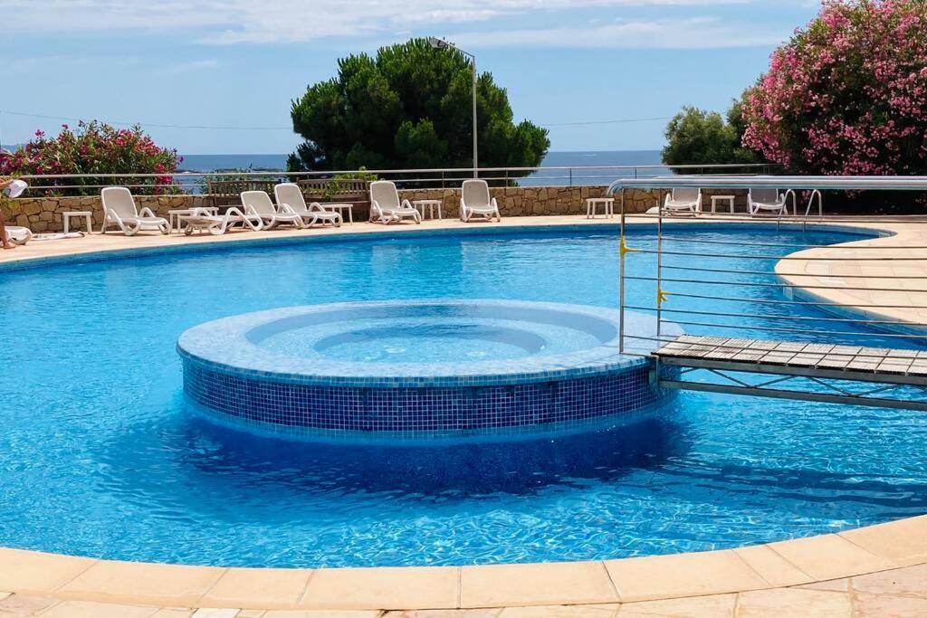阿雅克修Appartement VAIANA avec piscine en bord de mer的一个带椅子和蓝色水的大型游泳池