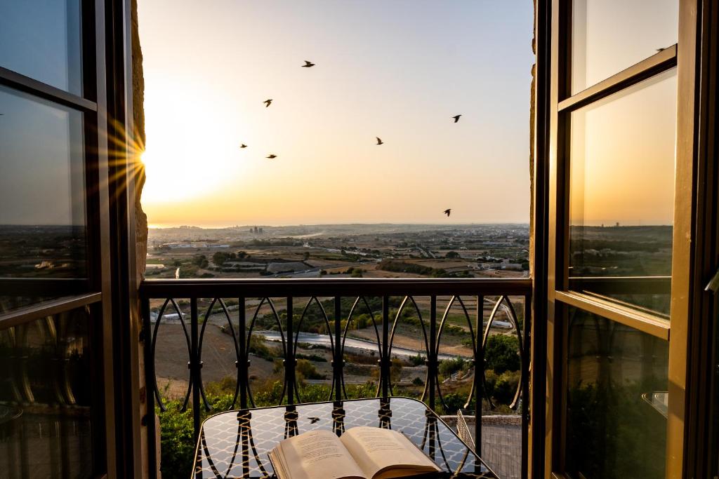 姆迪纳克拉皇宮城堡酒店的透过窗户欣赏美景,桌子上摆放着书籍