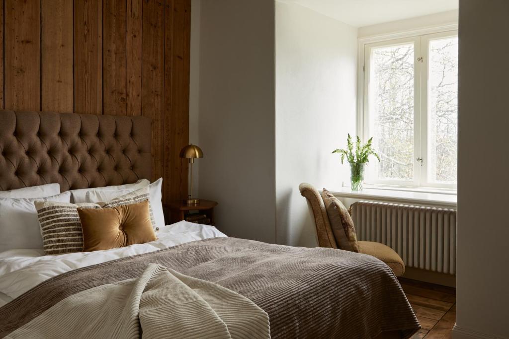 MusköArbottna Herrgård AB的一间卧室设有一张大床和一个窗户。