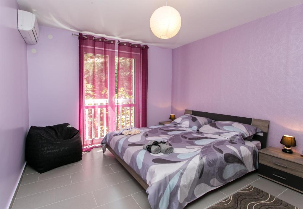 杜布罗夫尼克Apartment Lapad Bay的卧室设有紫色墙壁、床和窗户