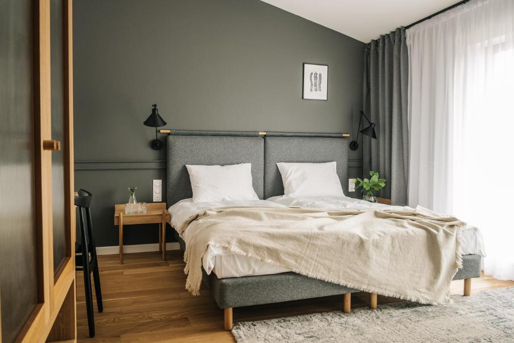 拉多姆斯科Apartamenty Las的一间卧室设有一张大床和灰色的墙壁