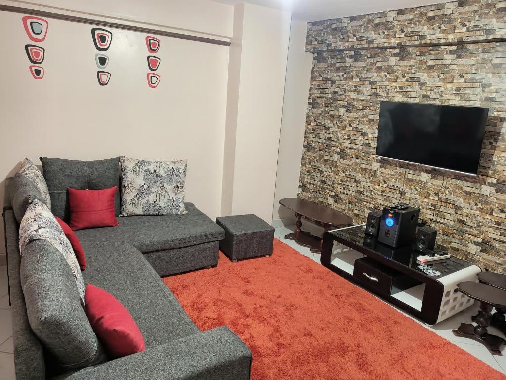 内罗毕Jayson Furnished Apartment, Nairobi的带沙发和平面电视的客厅