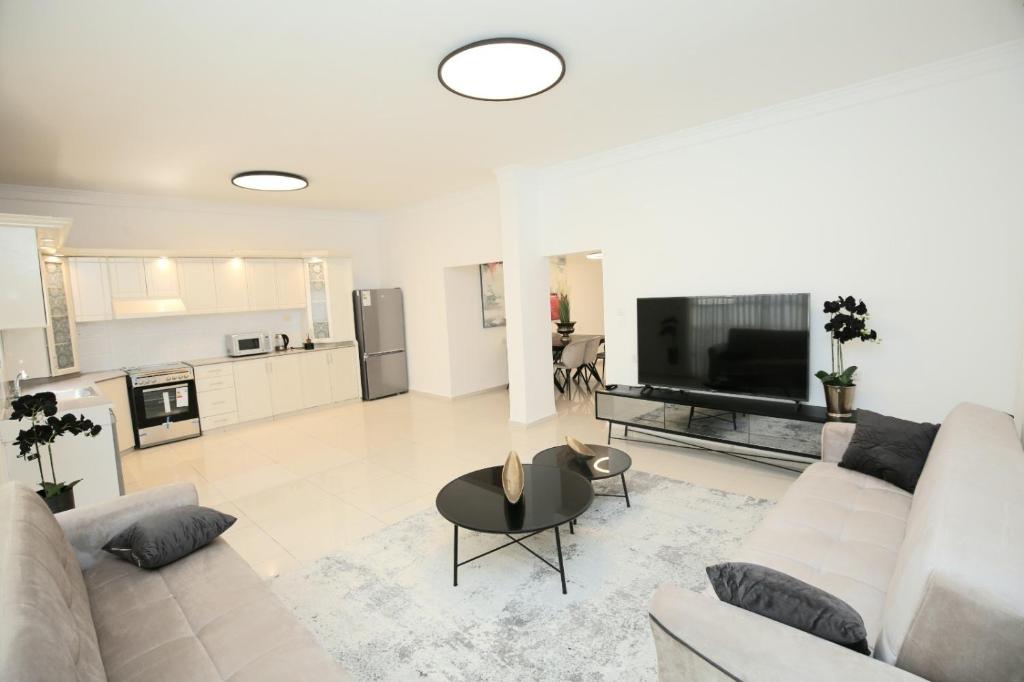 内坦亚City center luxury apartment in Netanya的白色的客厅配有沙发和桌子