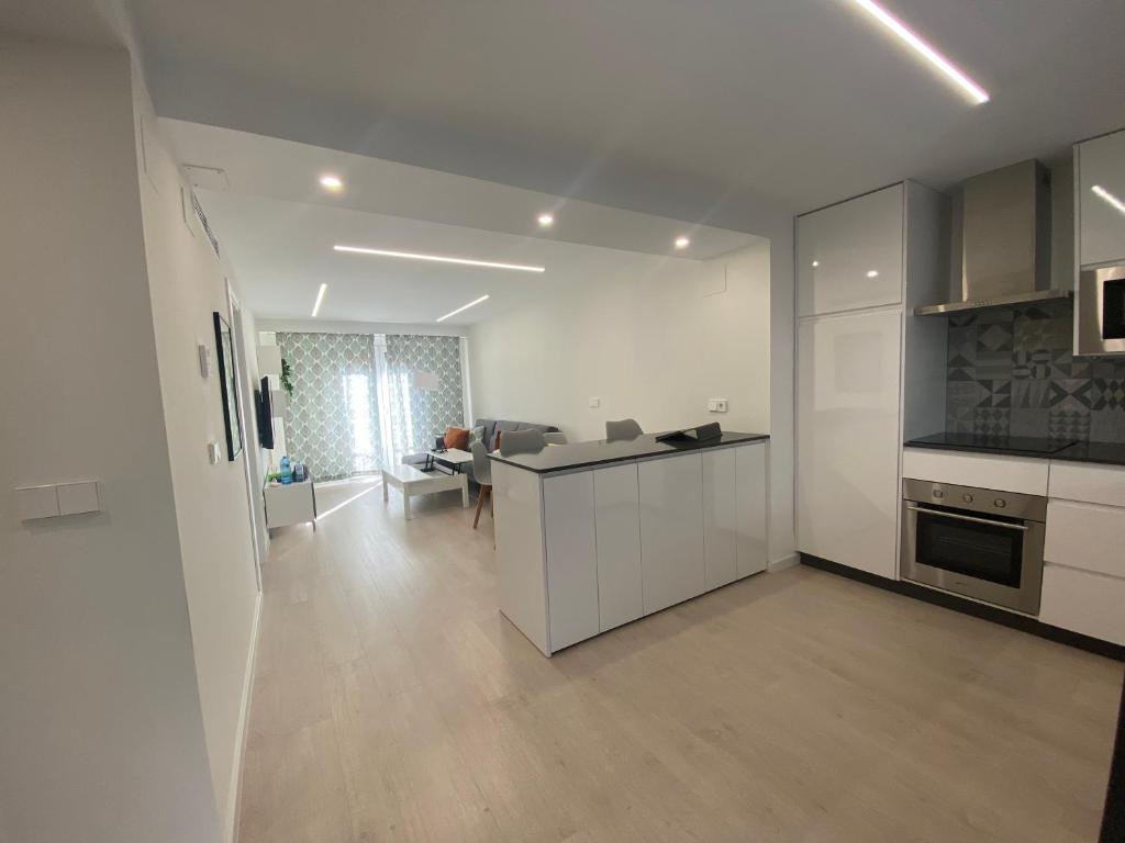 安特克拉Apartamento Andalucía Centro的一间带白色橱柜的厨房和一间客厅