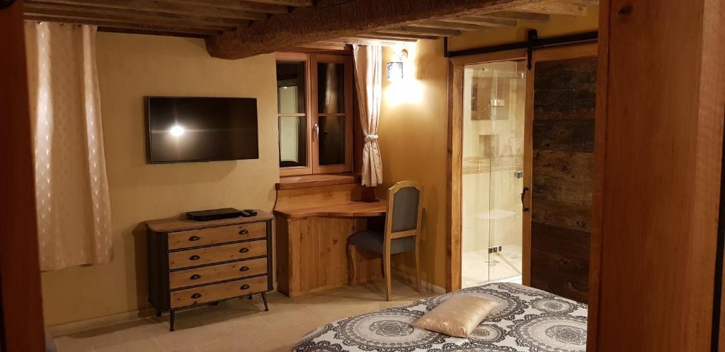 茹万维勒L'Attegia Lia的一间卧室配有一张床、一张书桌和一台电视
