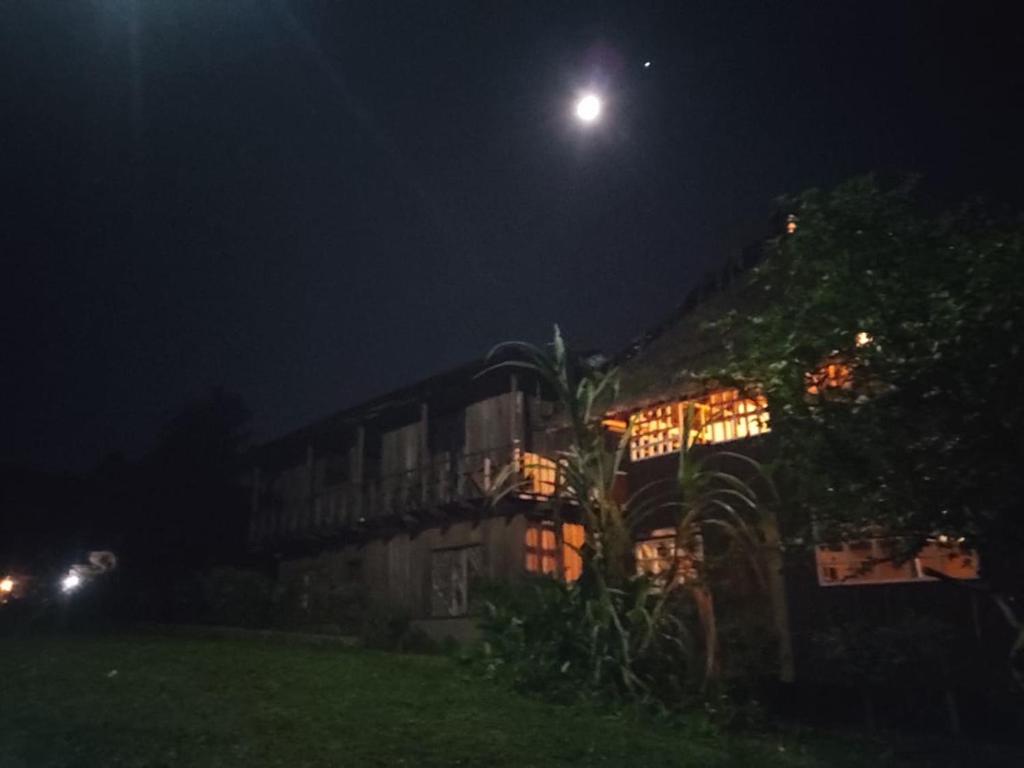 MoreliaHospedaje KOWAPANA BOCAS DE AMACAYACU的天空中月亮的夜晚房屋