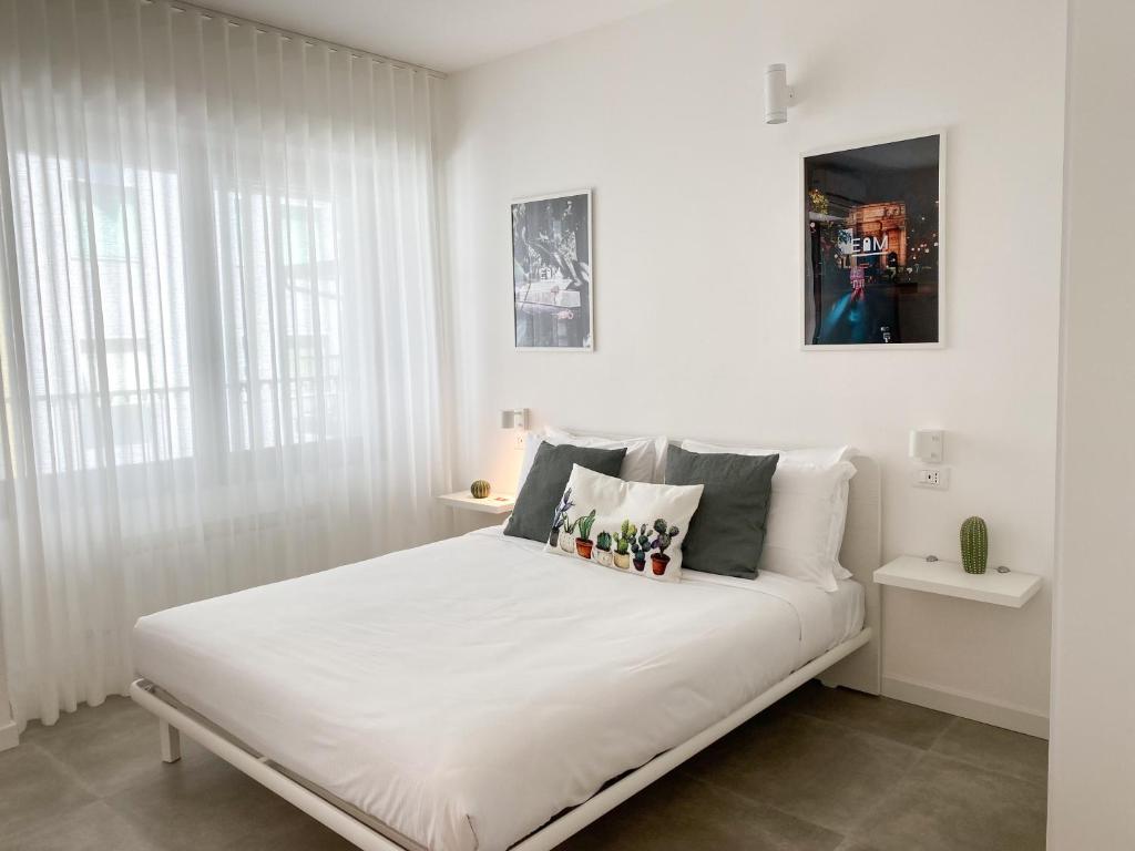 米兰Easy Milano Apartment Navigli的白色卧室配有一张带枕头的大白色床