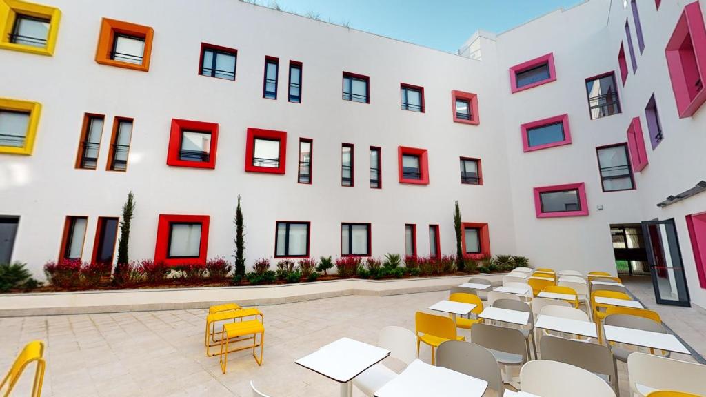 马拉加Residencia Universitaria Málaga Centro的前面设有桌椅的建筑