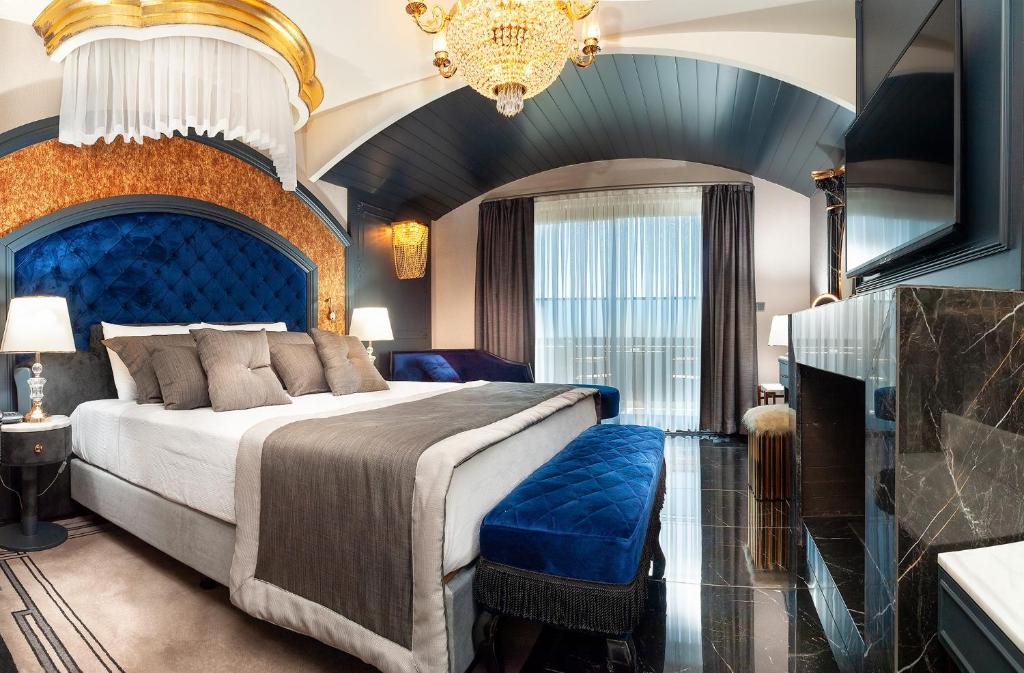 库萨达斯TNR Otel & Spa的一间卧室配有一张大床和蓝色床头板