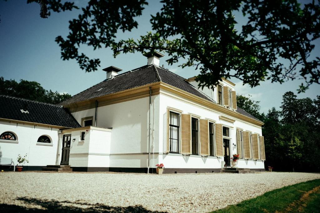 VeenhuizenKlein Soestdijk的黑色屋顶的白色旧房子