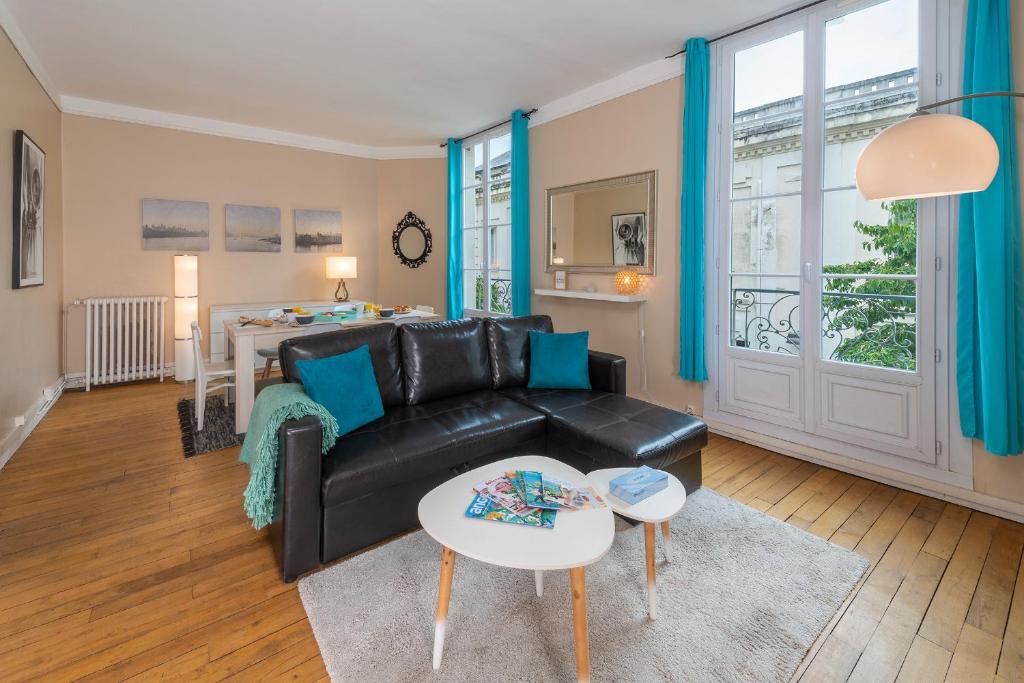 昂热Appartement Coeur de Ville rue Saint-Laud的客厅配有黑色真皮沙发和桌子