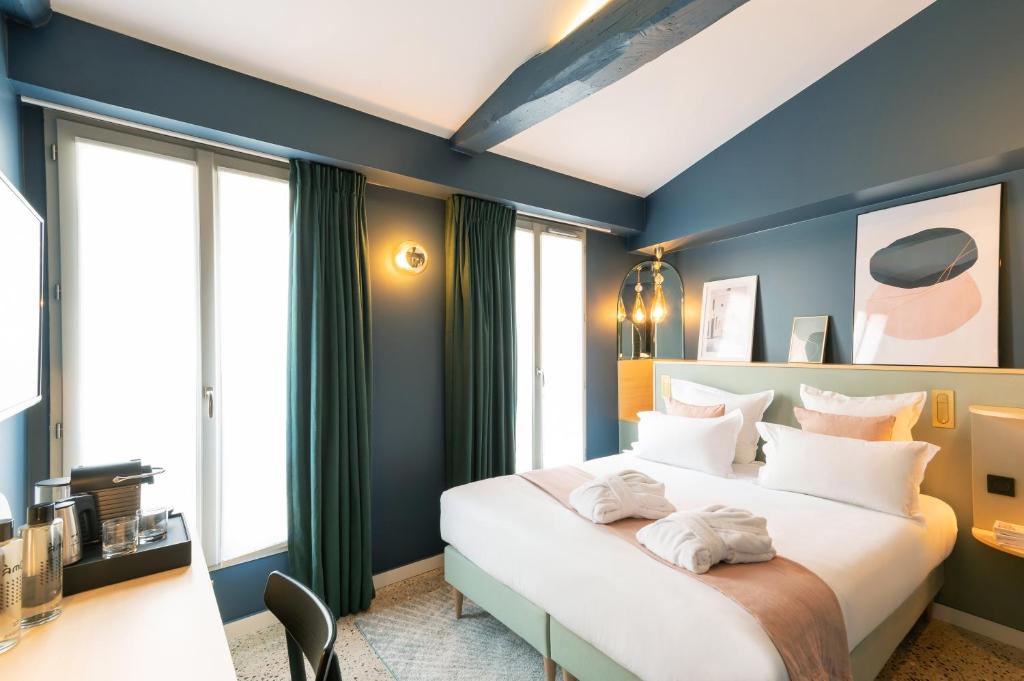 巴黎Hôtel Amoi Paris的卧室配有白色大床和蓝色的墙壁