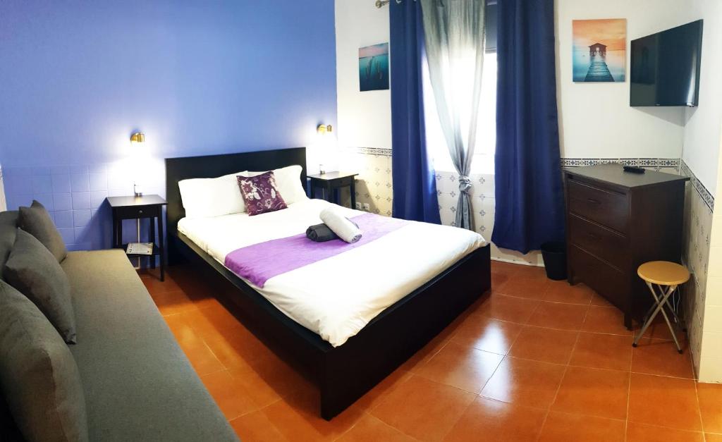 阿尔科巴萨Guesthouse of Alcobaça的一间卧室配有床、梳妆台和蓝色窗帘