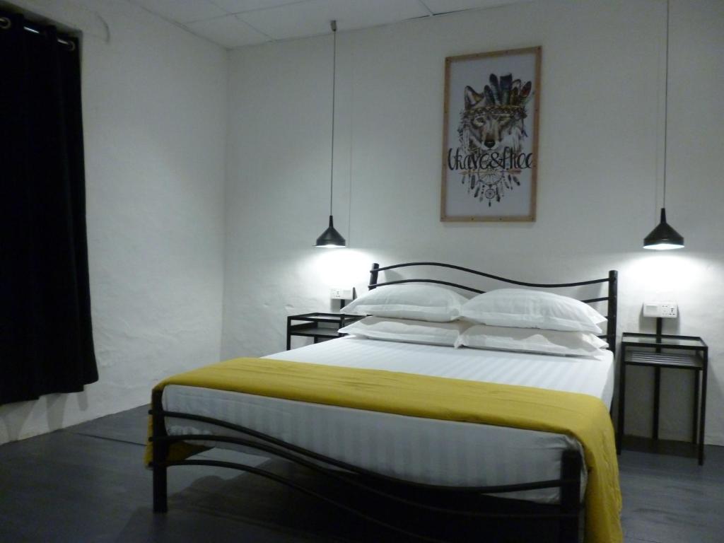 马六甲Ola Hostel的一间卧室配有一张带黄色毯子的大床