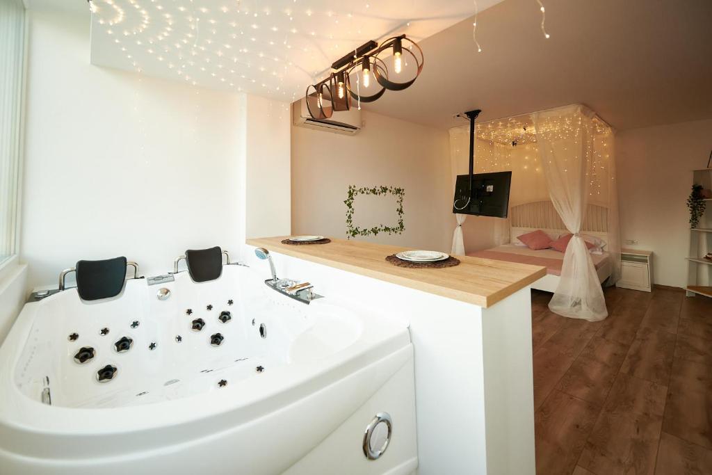 布拉索夫Romantic Studio的浴室配有白色浴缸和水槽