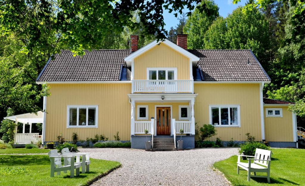 SvanåEden's Garden Cottages的白色门廊的大型黄色房屋