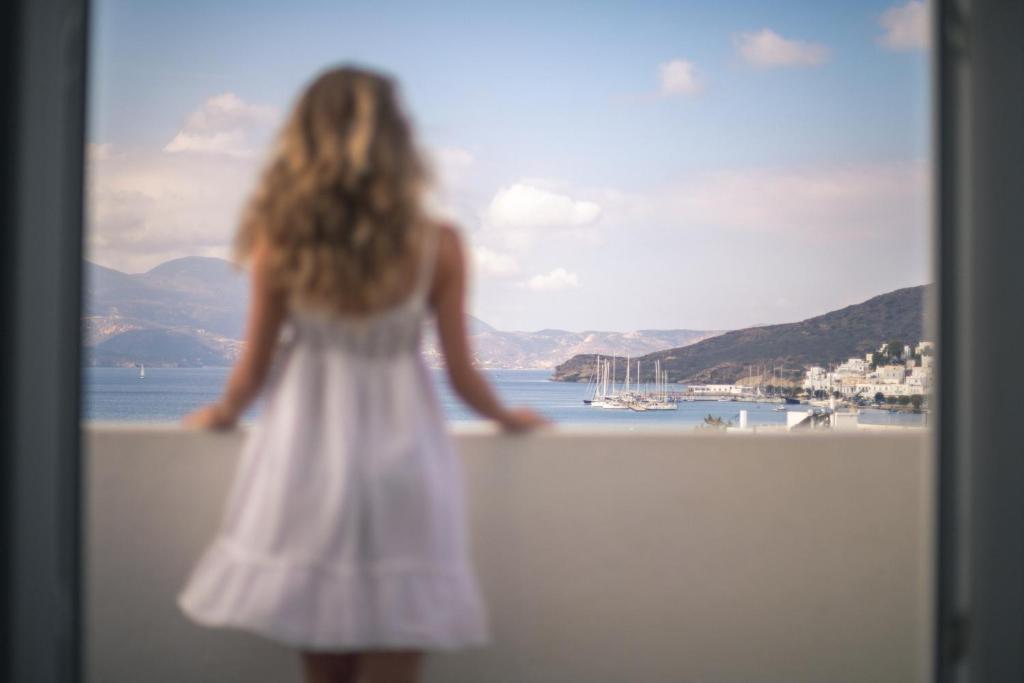 阿达玛斯宜普卡普斯一室公寓酒店的站在墙上的白色连衣裙的小女孩