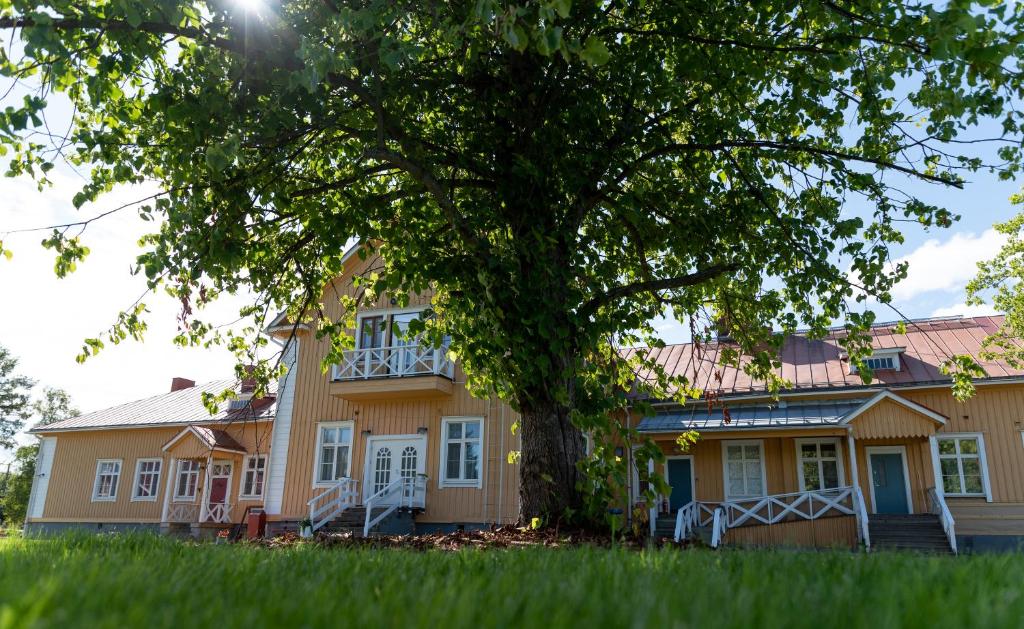 ItäkoskiMaaseutuhotelli Juopperin Kartano的前面有一棵树的房子