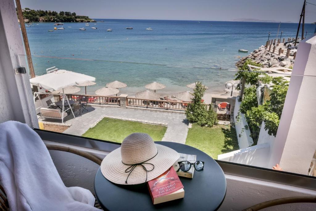 阿齐亚佩拉加Laia Seafront Luxury Apartments的坐在桌子上的一顶帽子,享有海景