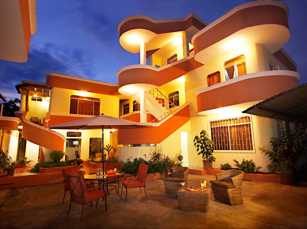 阿约拉港加拉帕戈斯太阳海岸酒店的一座大建筑前面设有桌椅