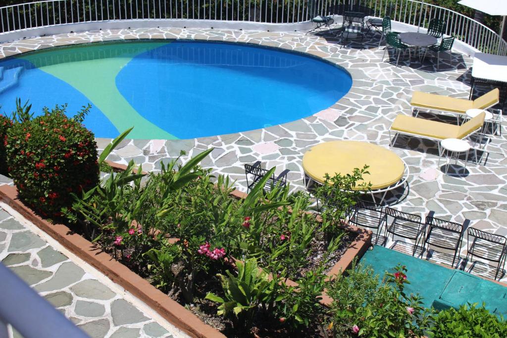 阿卡普尔科Hermosa Residencia Costa Azul Acapulco的一个带两把椅子的游泳池和一个庭院