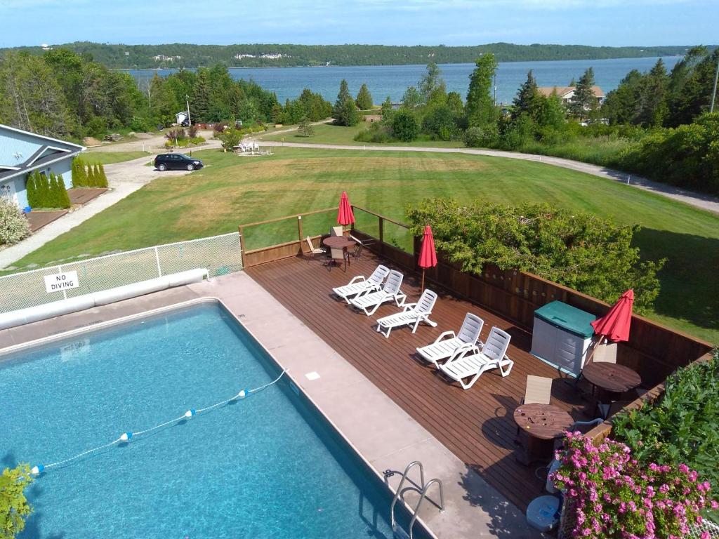 怀尔顿水景湾酒店的享有带椅子和遮阳伞的游泳池的上方景色