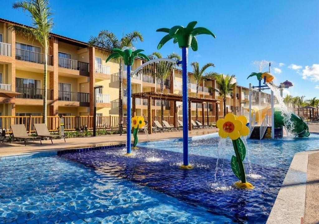塞古罗港Apartamento Ondas Resort的棕榈树和喷泉度假村的游泳池